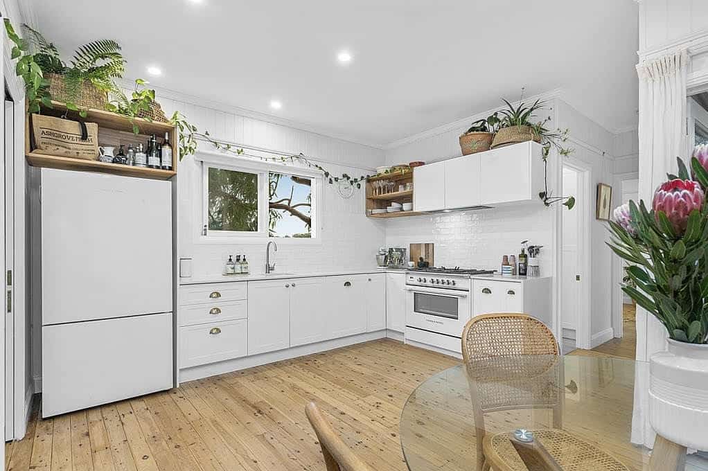 A white kitchen with wooden flooring